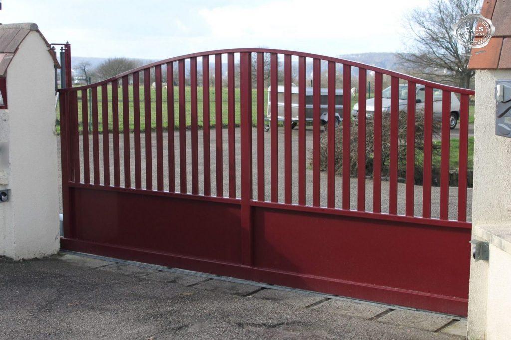 Portail moderne rouge rubis situé à Freneuse